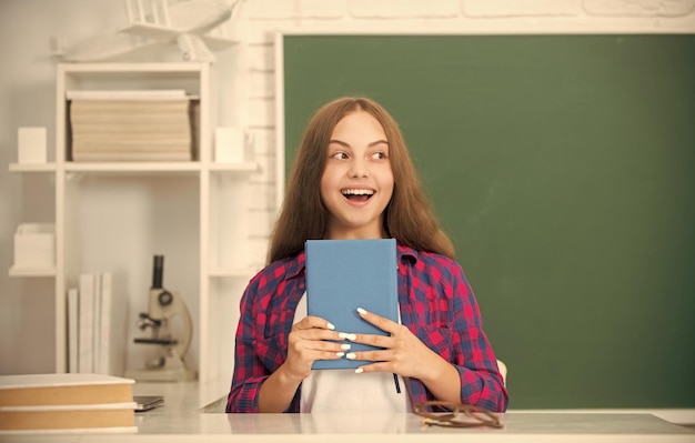 Niño asombrado hacer la tarea con el libro adolescente estudiante educación moderna colegiala de secundaria con cuaderno niño con cuaderno regreso a la escuela niña adolescente lista para estudiar