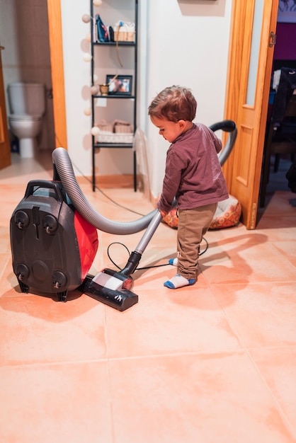 Niño aspirando en casa haciendo sus deberes