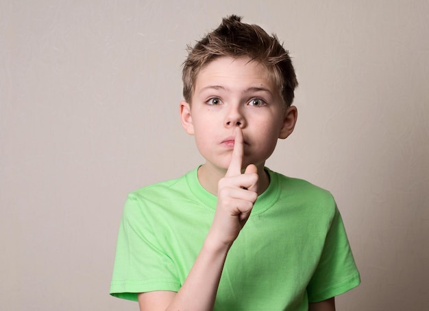 Niño asustado haciendo gesto de silencio Niño poniendo el dedo en los labios y pidiendo silencio