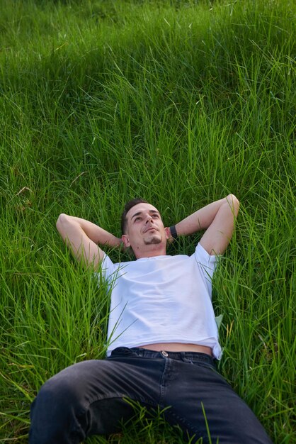 Foto un niño atractivo durmiendo pacíficamente en la hierba de un parque