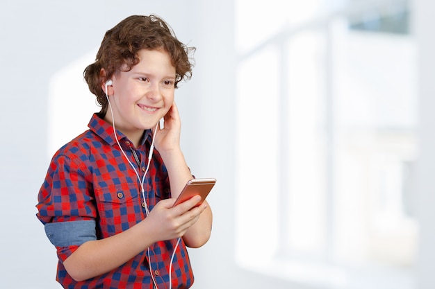 Niño atractivo es escuchar música con auriculares