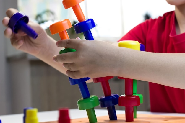 Un niño atrapa torretas que caen de piezas de plástico de colores.