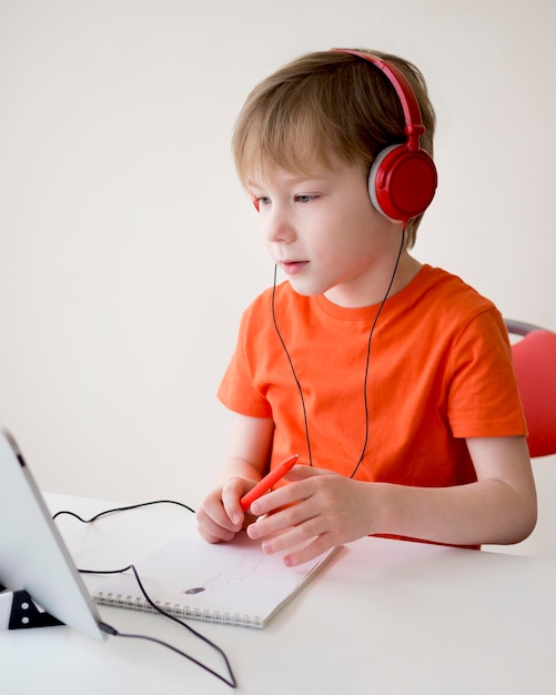 Foto niño con auriculares en una clase en línea