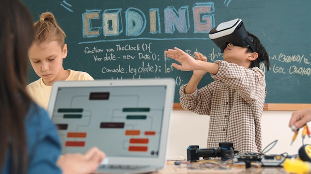 Un niño con auriculares de realidad virtual para entrar en el metamundo mientras una niña codifica el sistema de pedagogía