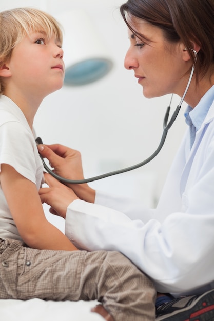 Niño auscultando por un médico