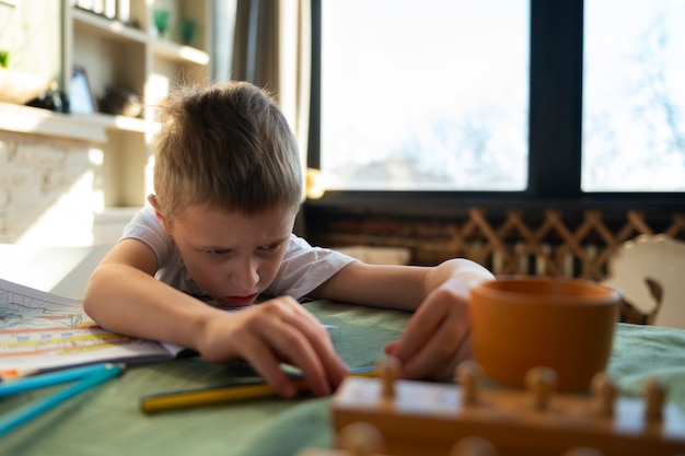 Foto niño autista estudiando en casa