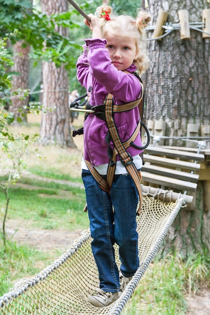 Niño en aventura escalando el parque high wire