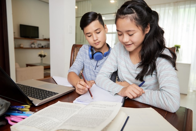 Niño ayudando a una amiga con la tarea