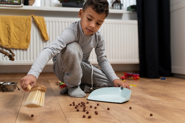 Foto niño ayudando a limpiar la casa sucia