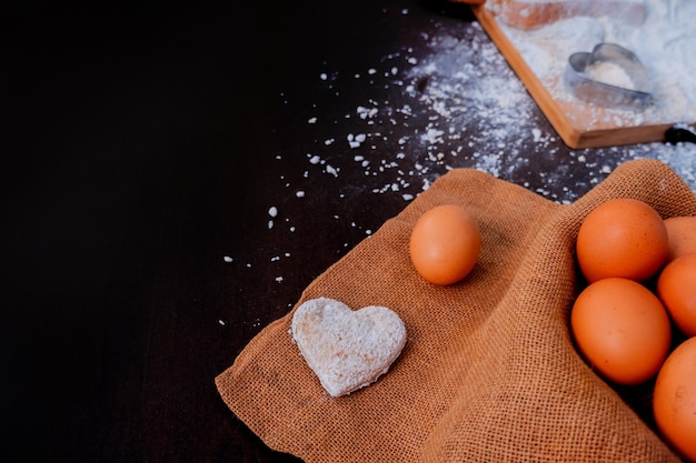 niño ayudando a mamá a cocinar para el día de San Valentín. Preparación de un ingrediente con polvo y harina. Cocina sucia y desordenada.