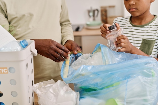 Niño ayudando a su papá a ordenar la basura