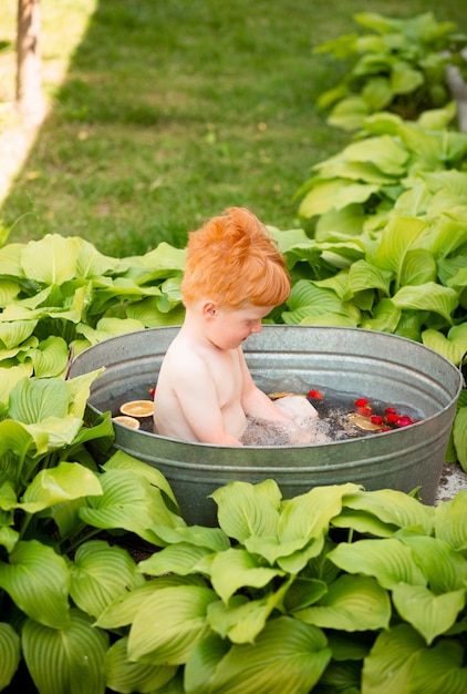 Un niño se baña en un baño de verano.