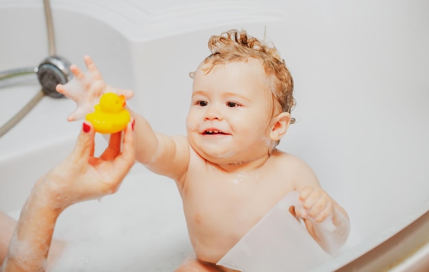 Niño bañándose en la bañera divertido bebé feliz se baña en la bañera con agua y espuma niños higiene sonriendo k