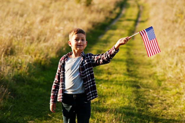 Niño con bandera de Estados Unidos al aire libre. América celebrando.