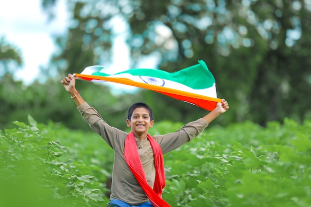 Niño con la bandera india en la naturaleza