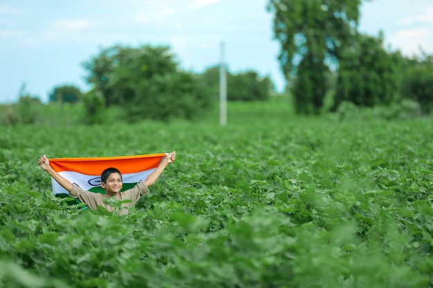 Niño con la bandera india en la naturaleza