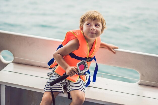 Un niño en un barco con una cámara de acción está listo para bucear