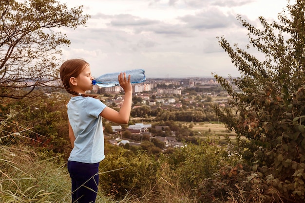 El niño bebe agua de una botella durante el viaje.