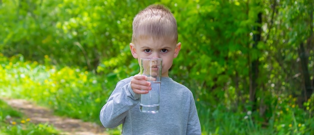 El niño bebe agua limpia en verano.