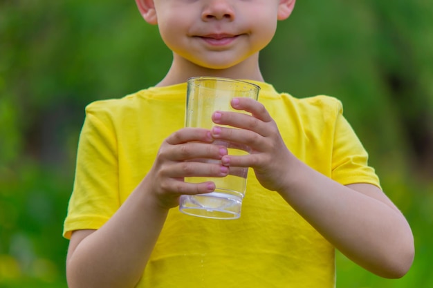 El niño bebe agua de un vaso Agua pura Verano