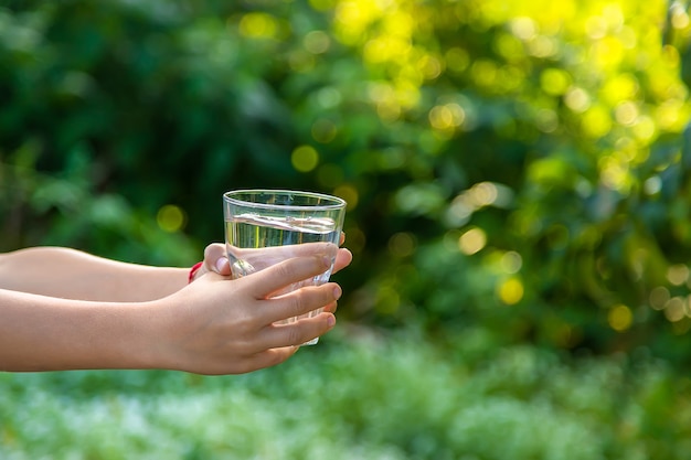 El niño bebe agua de un vaso. Enfoque selectivo. Niño.