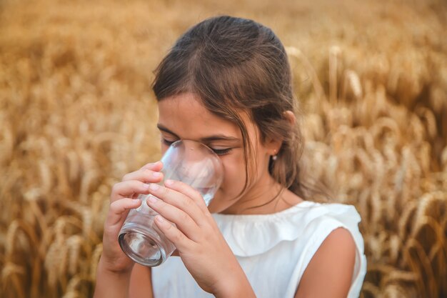 El niño bebe agua de un vaso. Enfoque selectivo.