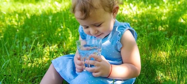 Foto el niño bebe agua de un vaso enfoque selectivo