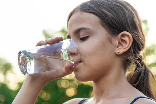 El niño bebe agua de un vaso Enfoque selectivo