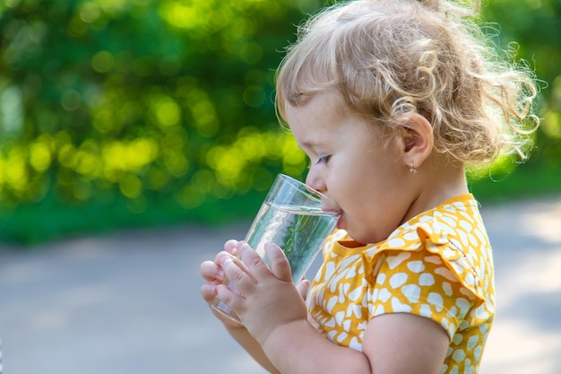 El niño bebe agua de un vaso Enfoque selectivo