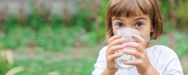 Foto niño bebe agua de un vaso enfoque selectivo