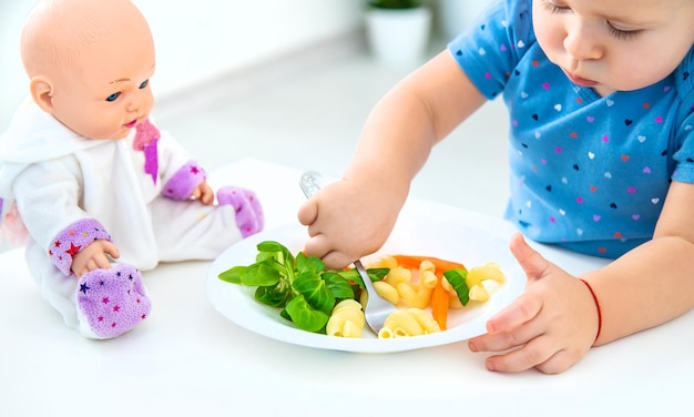 Niño bebé come pasta con verduras Enfoque selectivo Alimentos