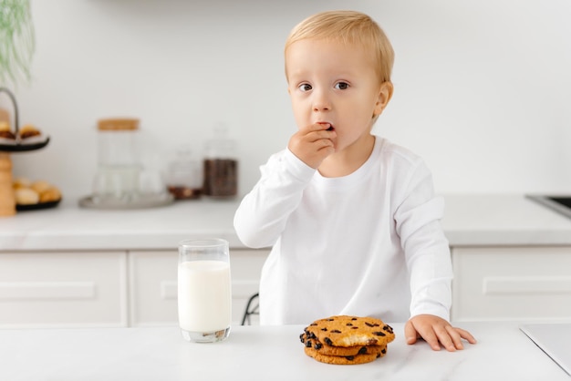 Niño bebe leche y galletas por la mañana galletas de avena con leche