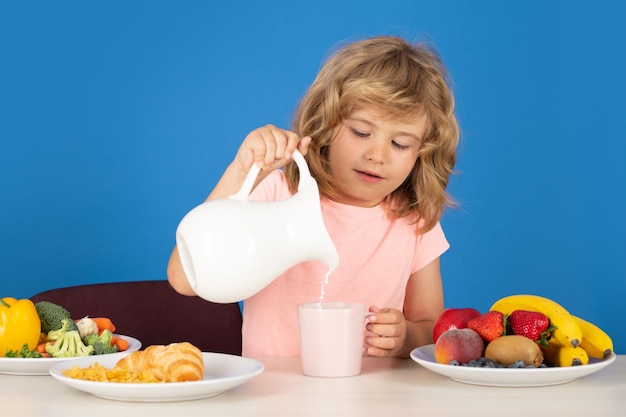 Niño bebe leche láctea niño niño vertiendo leche de vaca entera retrato de niño comer alimentos frescos y saludables en s