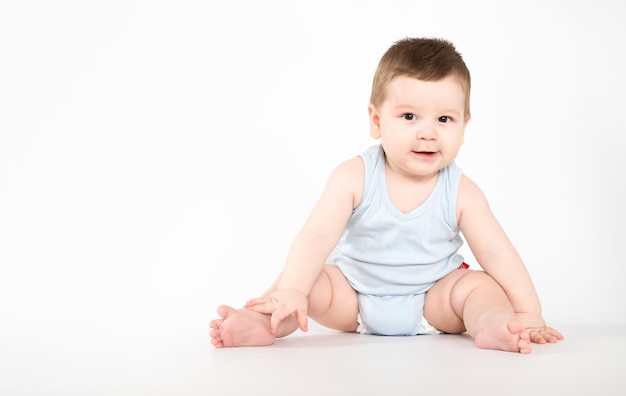 Niño bebé niño sentado feliz niño sonriente sobre un fondo de mes blanco