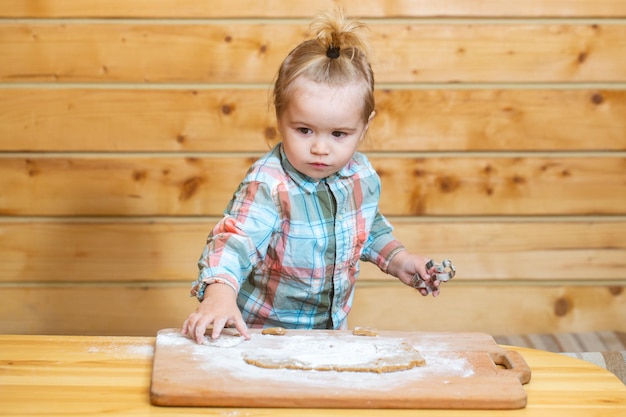 Niño bebé preparando la masa para hornear galletas en la cocina