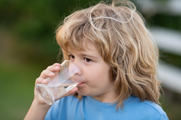 Niño bebiendo agua al aire libre en el parque