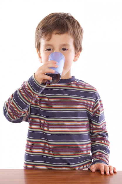 Niño bebiendo un refresco sobre fondo blanco