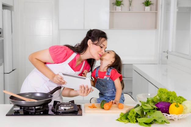 Niño besando a su madre en la cocina