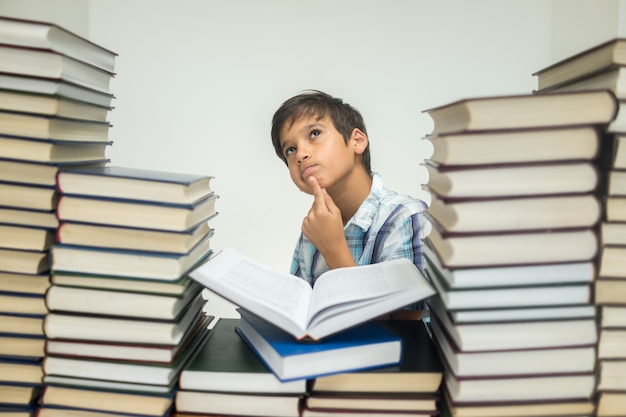 Un niño en la biblioteca leyendo libros