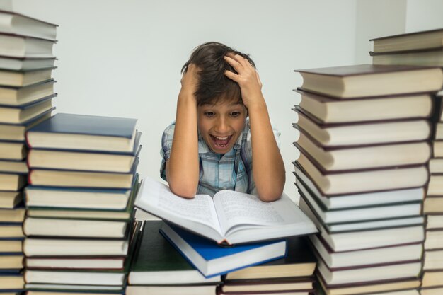 Un niño en la biblioteca leyendo libros