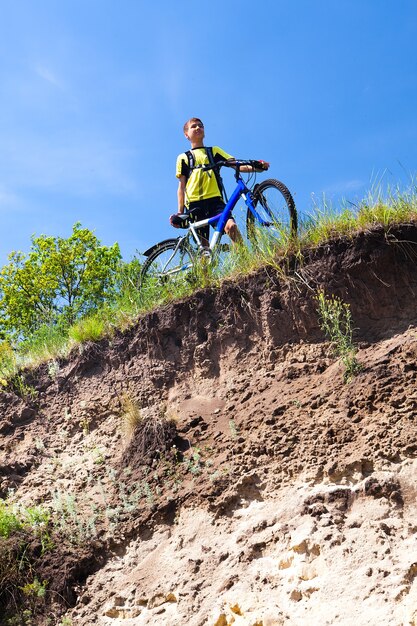 Foto niño en bicicleta cerca de un acantilado