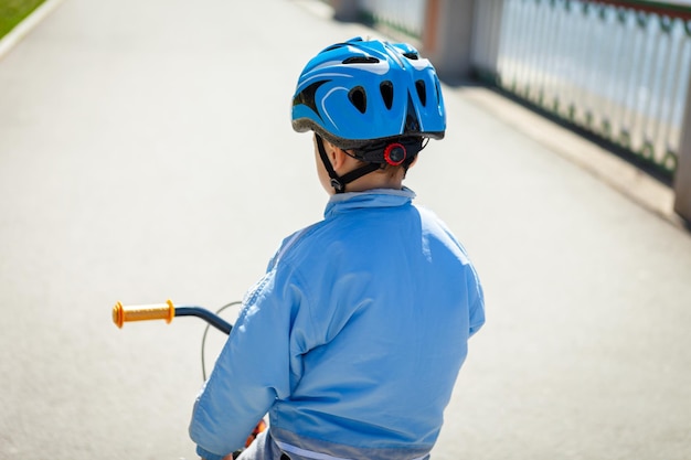 Foto niño en bicicleta con chaqueta azul y casco