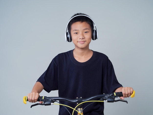 Niño con bicicleta sobre fondo claro