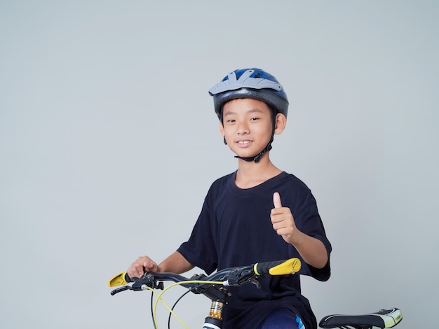 Niño con bicicleta sobre fondo claro