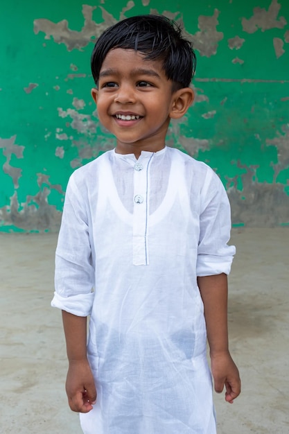 Un niño blanco de Punjabi que lleva dos años está sonriendo y mirando hacia otro lado haciendo por diversión Vistas de primer plano de la cara de un niño de 2 años