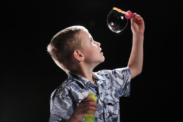 niño con bola de jabón