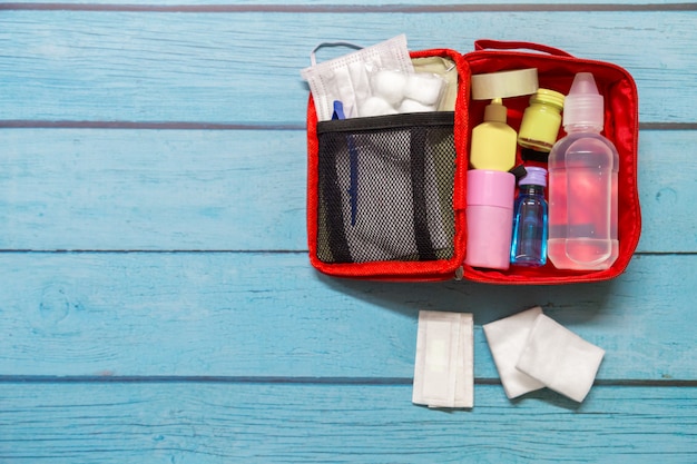 Niño del bolso de los primeros auxilios de la visión superior con suministros médicos en el fondo de madera.