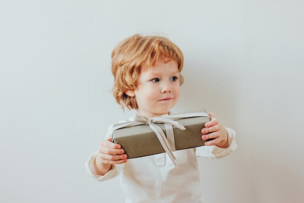 Niño bonito con caja de regalo, estilo minimalista.