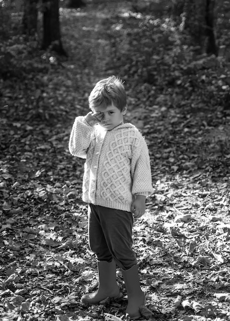 Niño con botas de goma caminando en el bosque lindo concepto turístico bosque escuela es educación al aire libre entregar