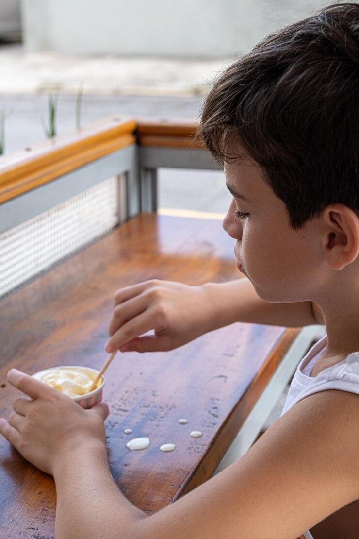 Foto niño brasileño de 10 años comiendo helado en una tarde soleada_9